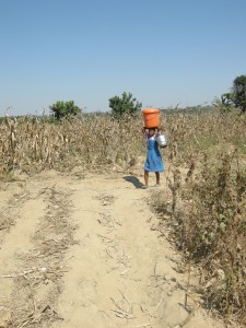 Noch vor der Schule holt die elfjährige Chimwemwe Wasser für die Familie. (Foto: dpa)